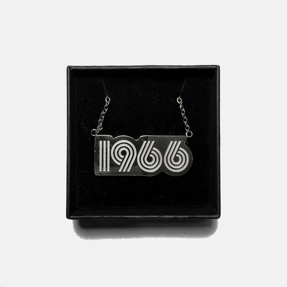 Necklace with '1966' design in a black box on a white background