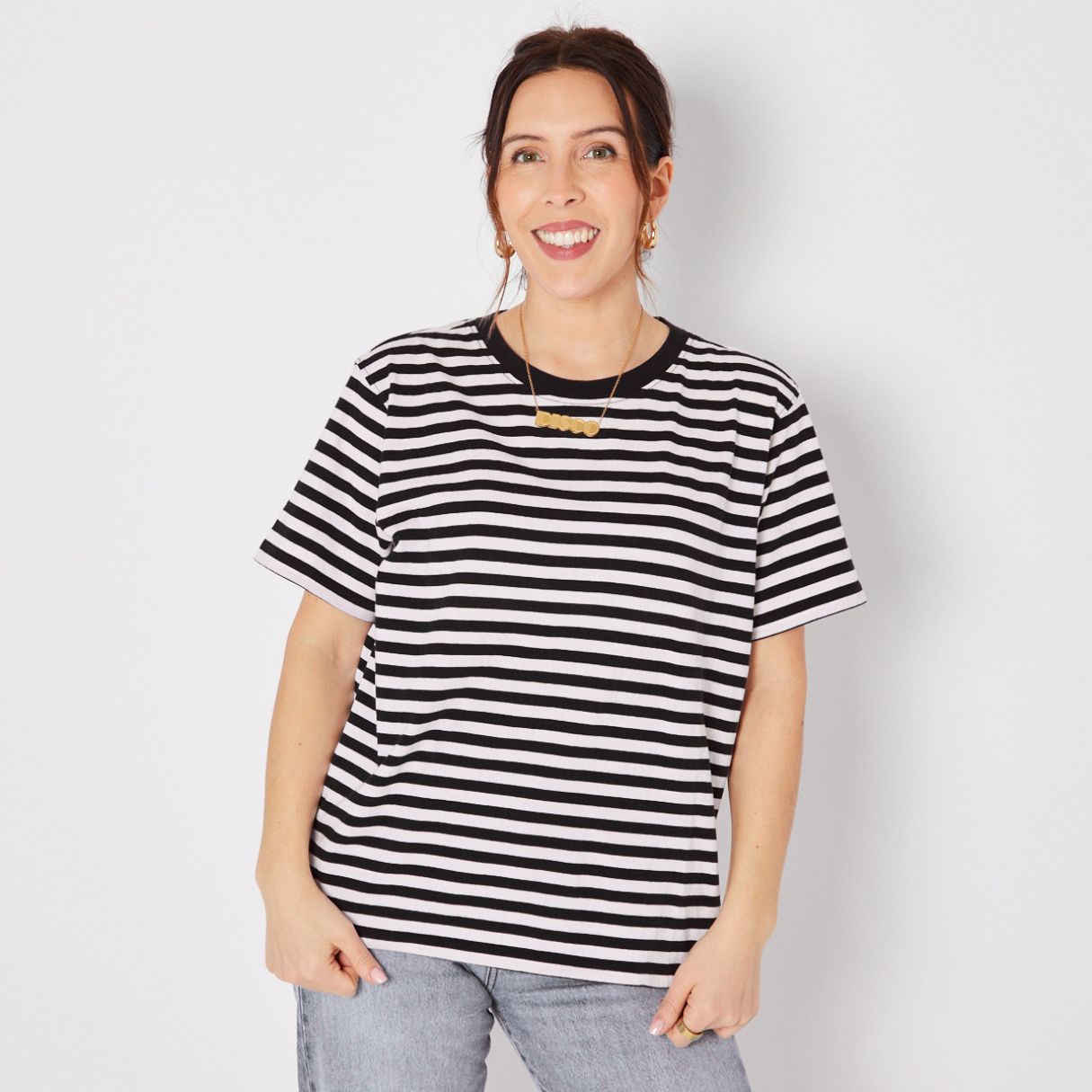 Woman wearing a black and white striped t-shirt against a plain background donna tshirt disko kids
