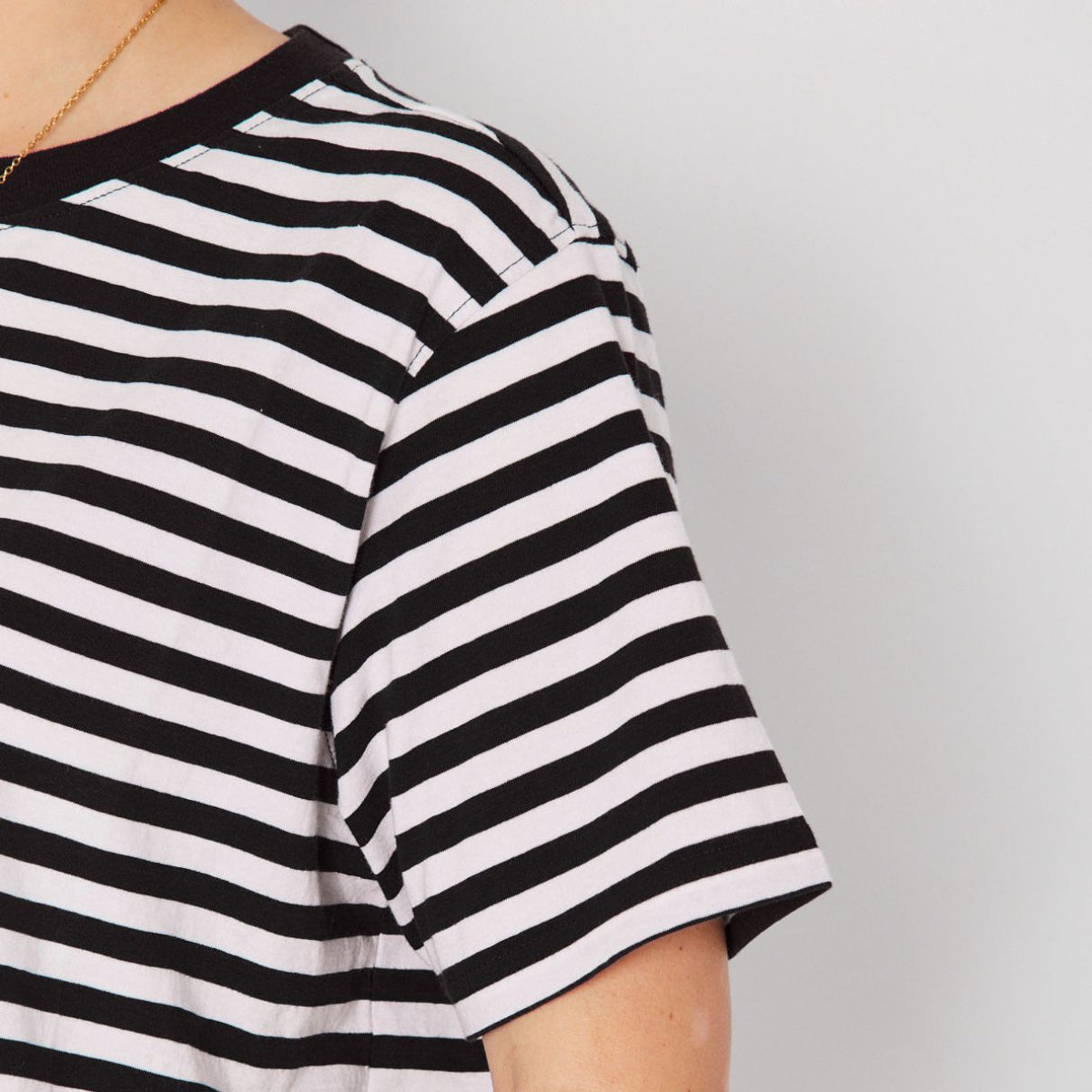Woman wearing a black and white striped t-shirt against a plain background donna tshirt disko kids