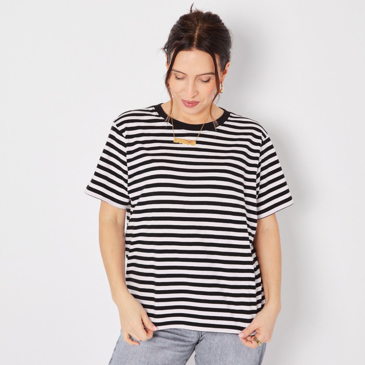 Woman wearing a black and white striped t-shirt against a plain background donna tshirt disko kids