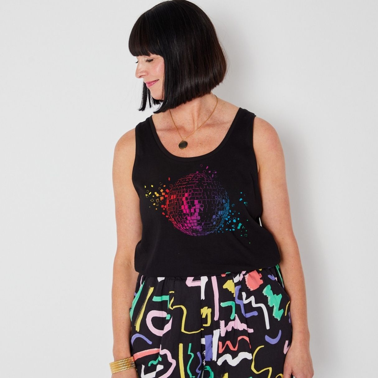 disko kids metallic rainbow disco ball on a black vest styled for festivals this summer