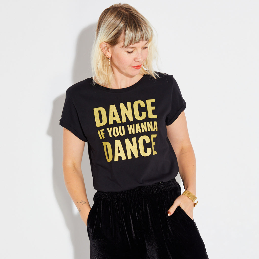 'DANCE IF YOU WANNA DANCE' in gold print on a white background