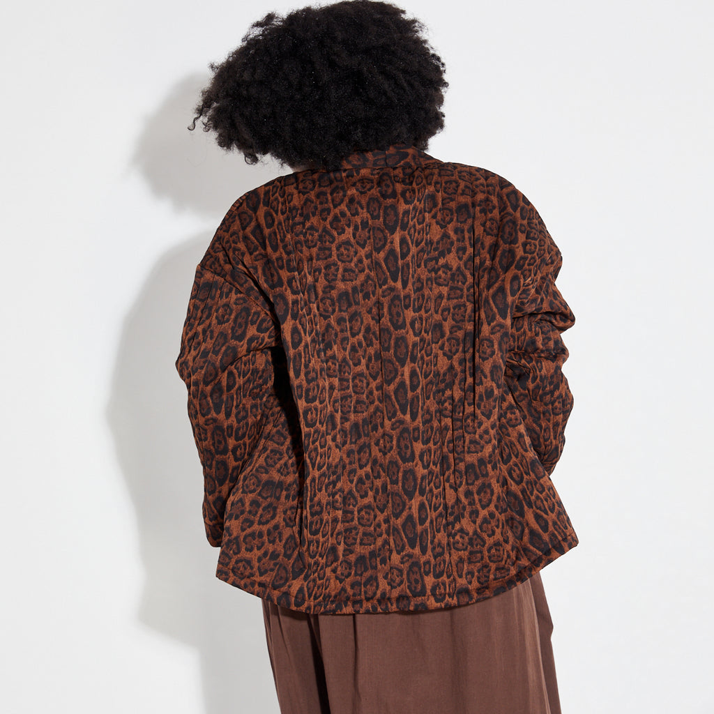 Person wearing a leopard print jacket on a white background