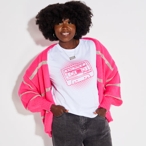 Woman wearing a pink stripe disco cardigan over a white t-shirt with a graphic design on a plain background