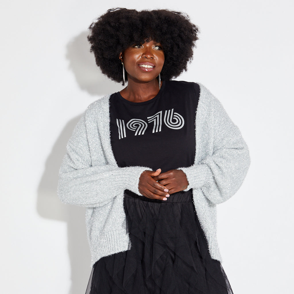 Woman wearing silver sparkly cardigan with black disco tshirt