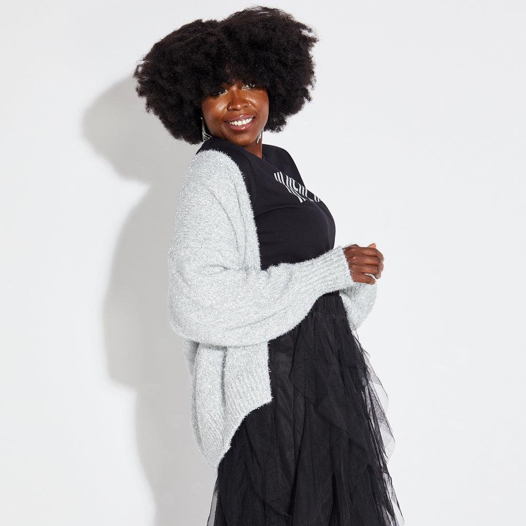 Woman wearing silver sparkly cardigan with black disco tshirt