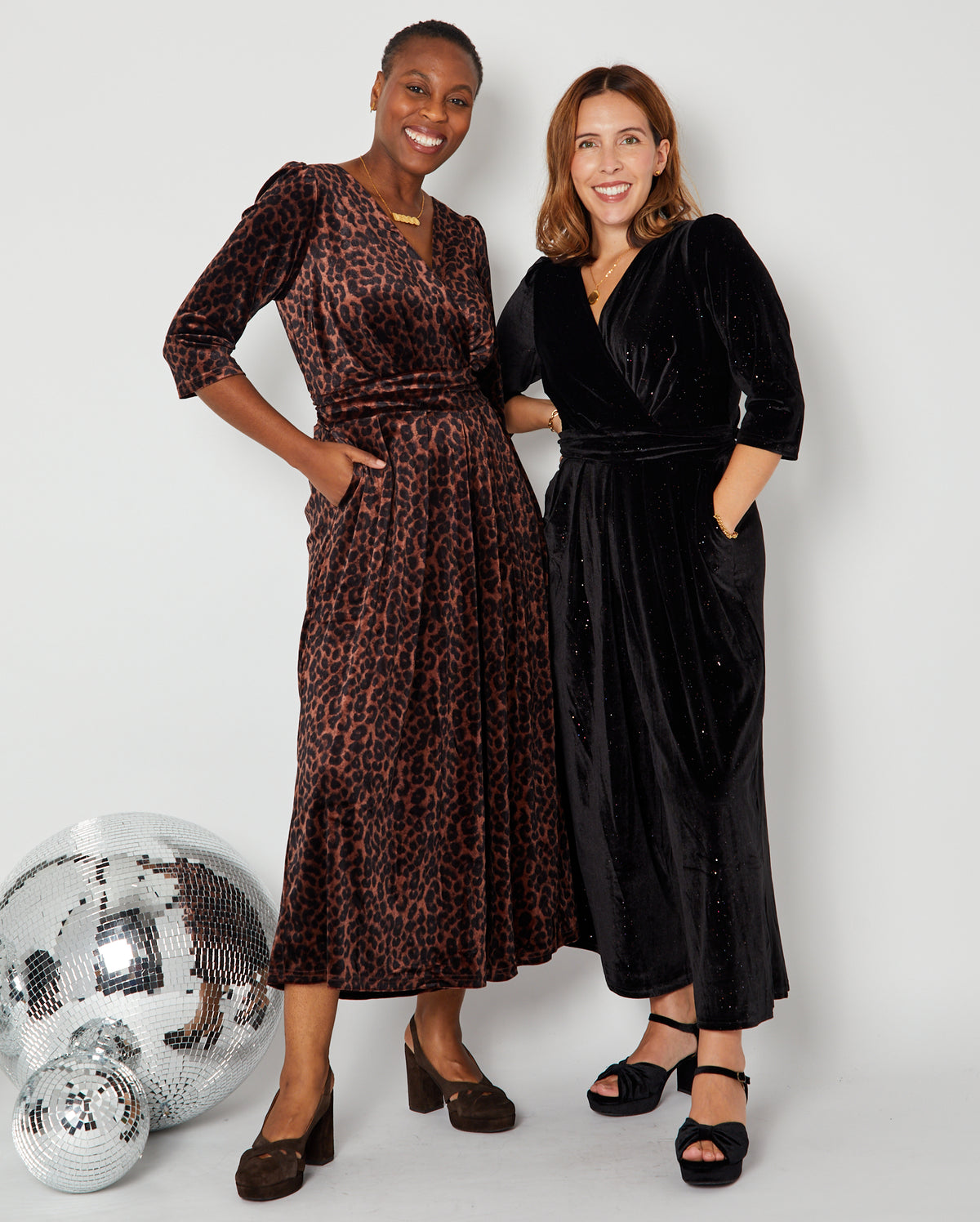 two models in Disko Kids partywear collection jumpsuits one leopard and one black rainbow sparkle