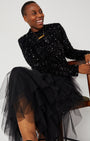 Black Layered Frill Tulle Skirt seated pose with sequin top and gold DISCO pendant