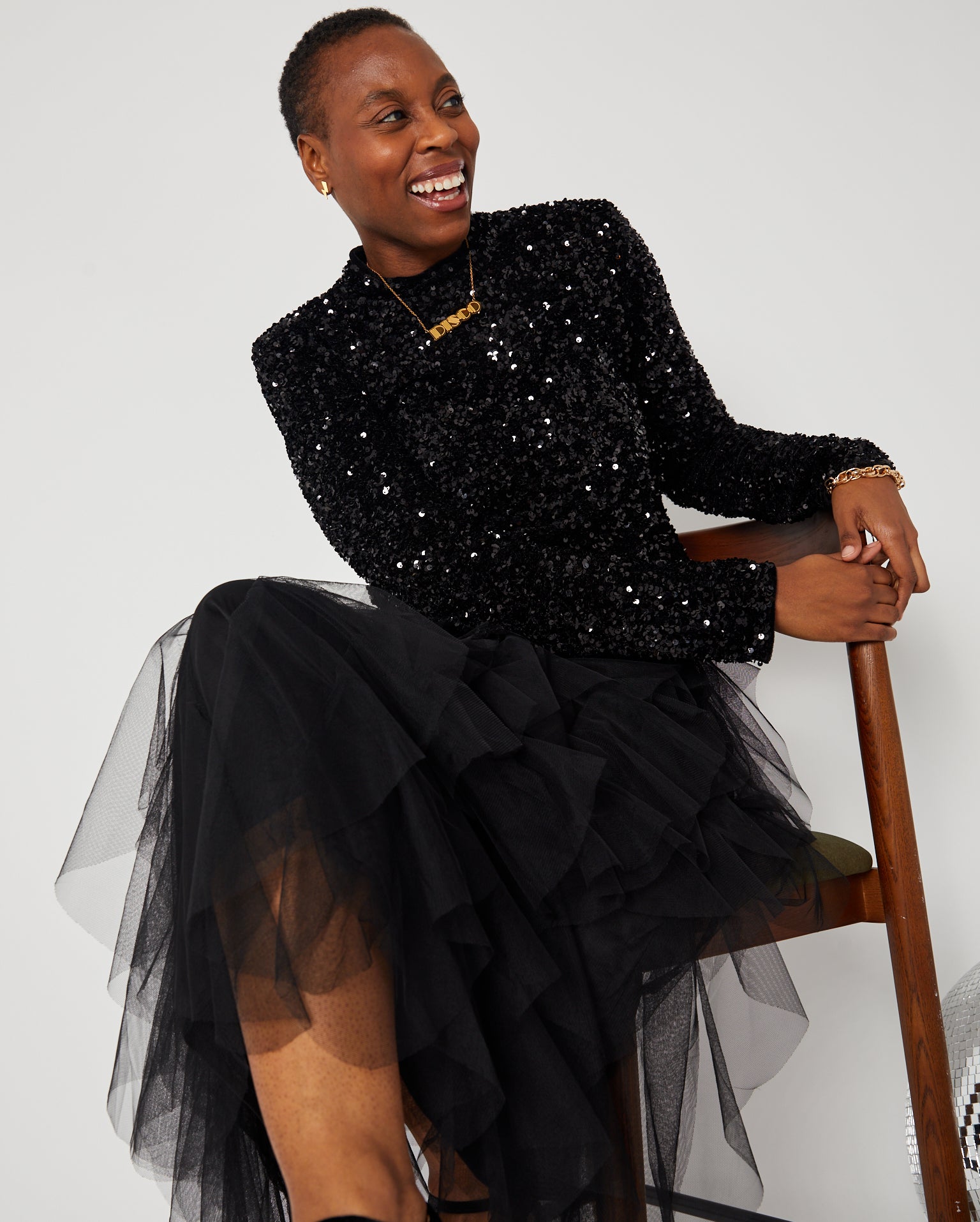 Black Layered Frill Tulle Skirt seated pose with sequin top and gold DISCO pendant