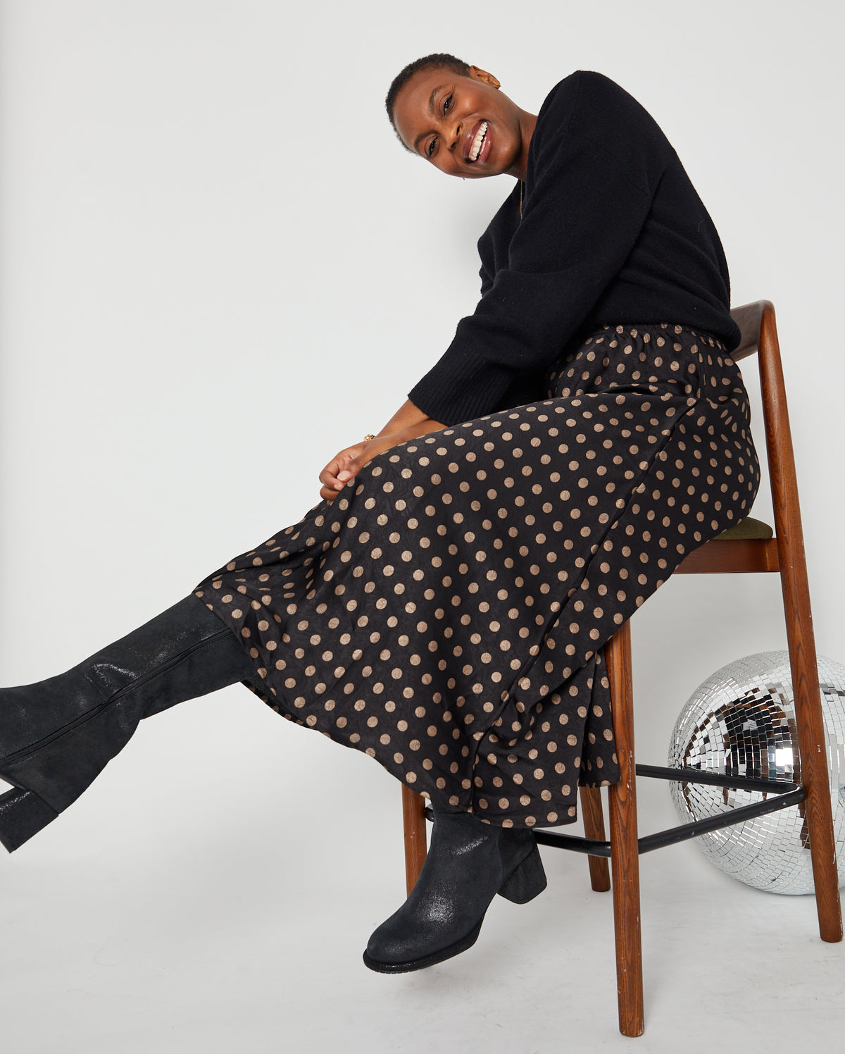 Polka Dot Satin Skirt side view on chair black and gold spots styled with a knit