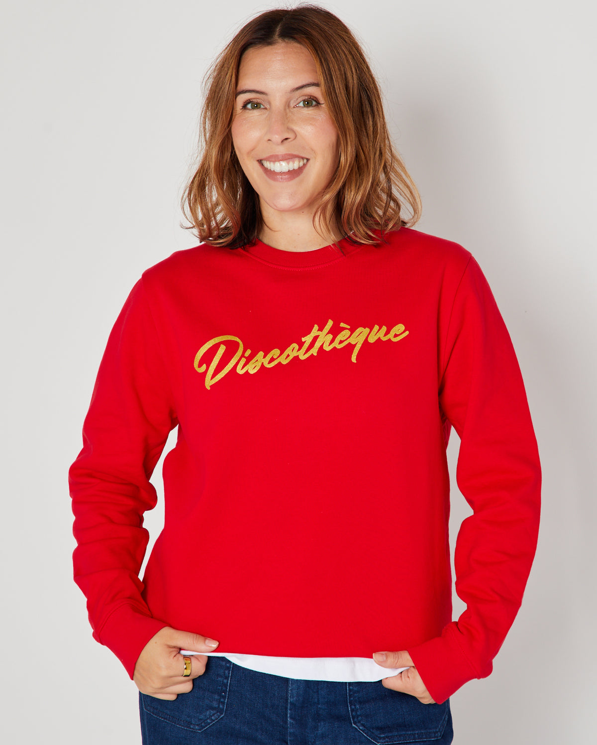 bright red crewneck sweatshirt with 'Discothèque' printed in gold script across the chest,