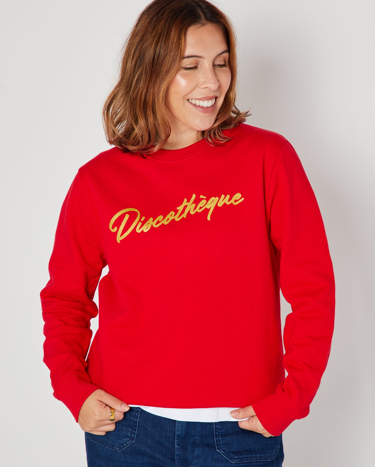 bright red crewneck sweatshirt with 'Discothèque' printed in gold script across the chest,