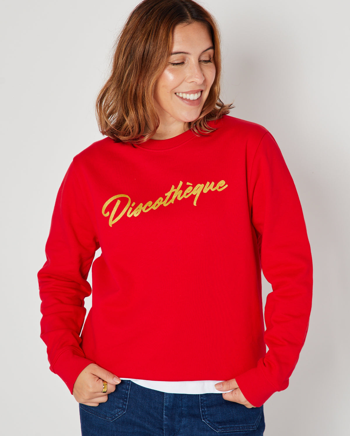 bright red crewneck sweatshirt with 'Discothèque' printed in gold script across the chest,