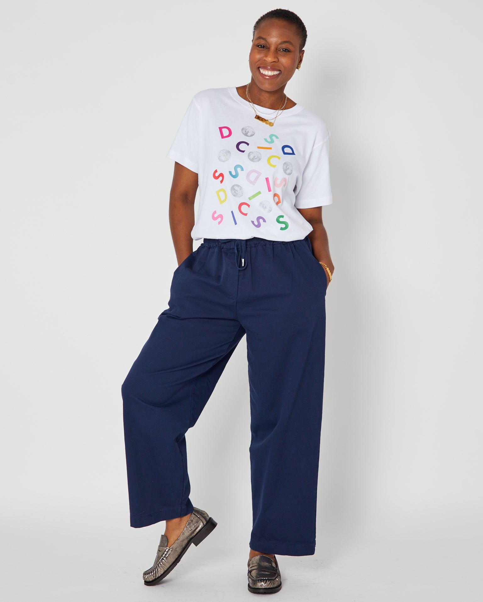 navy barrel leg trousers styled with disco confetti tshirt and loafers