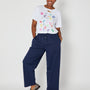 navy barrel leg trousers styled with disco confetti tshirt and loafers