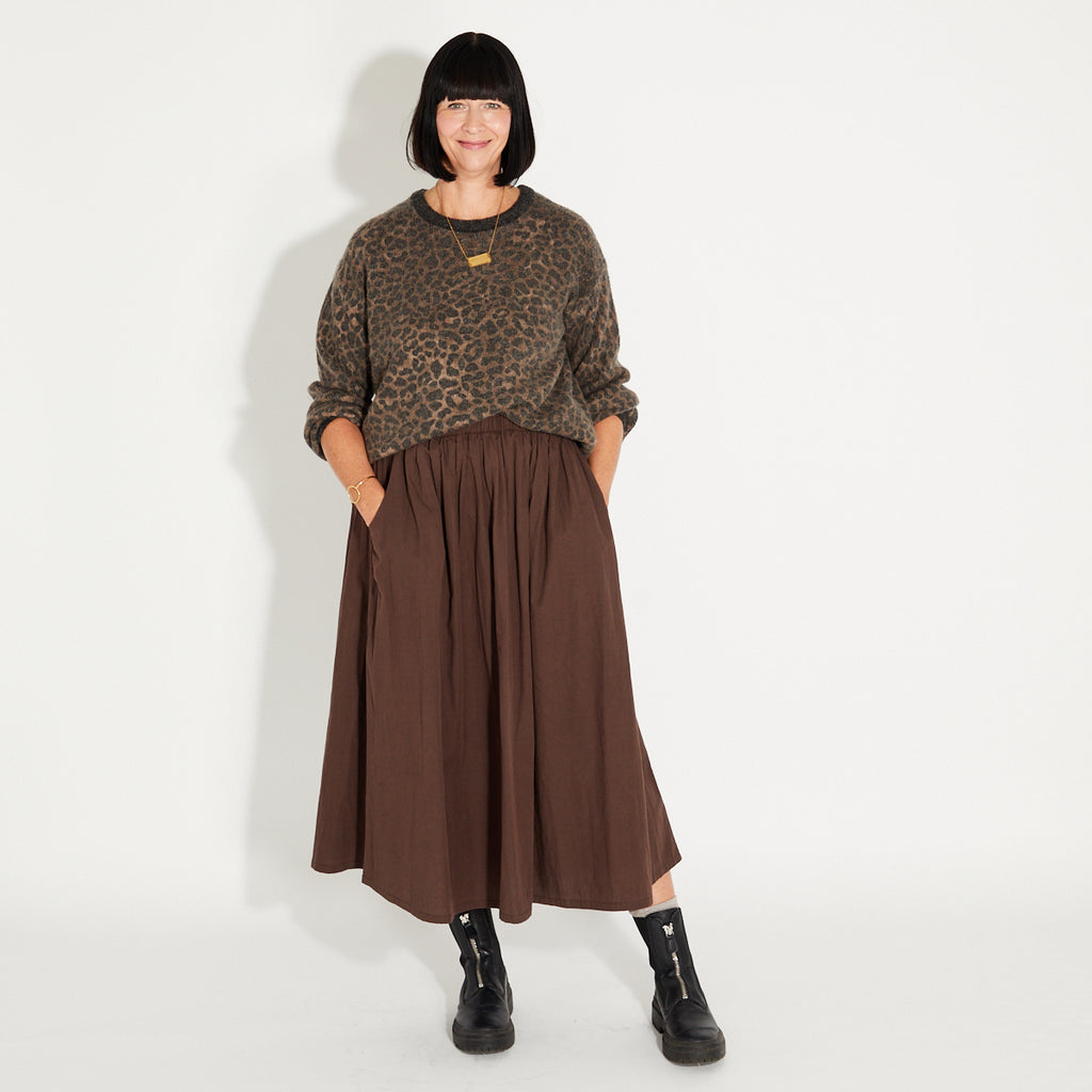 Woman wearing a leopard print jumper and chocolate brown a-libe skirt 