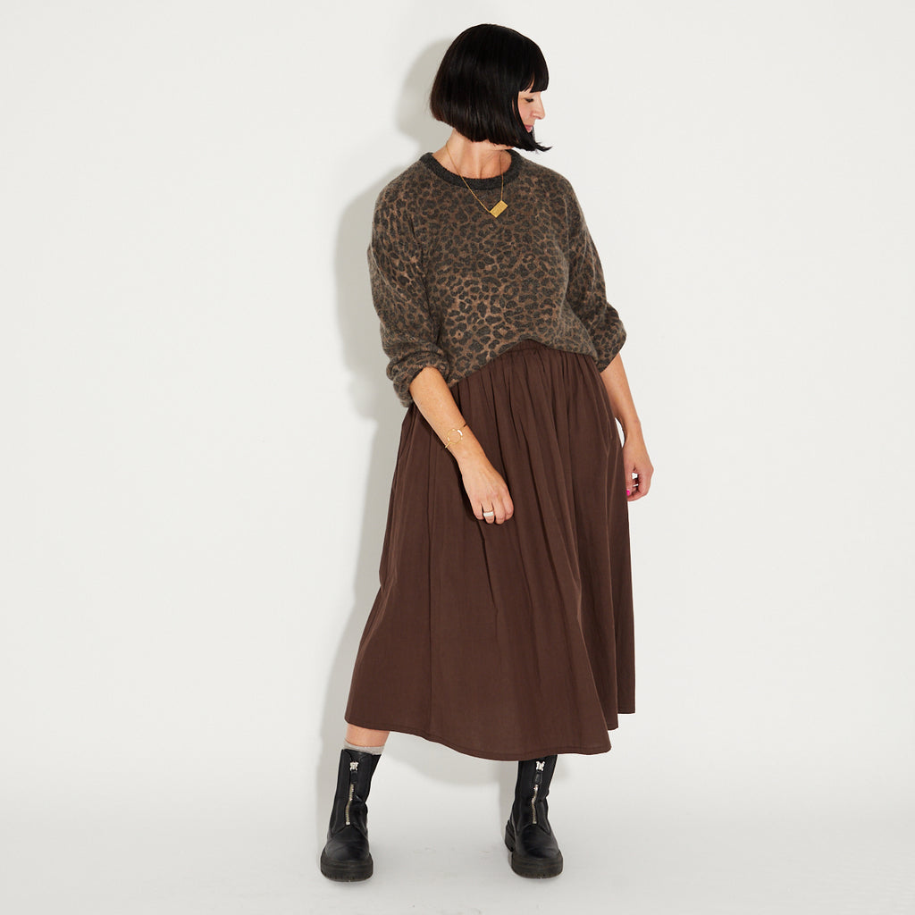 woman wearing a leopard print knitted jumper and chocolate brown a-line skirt
