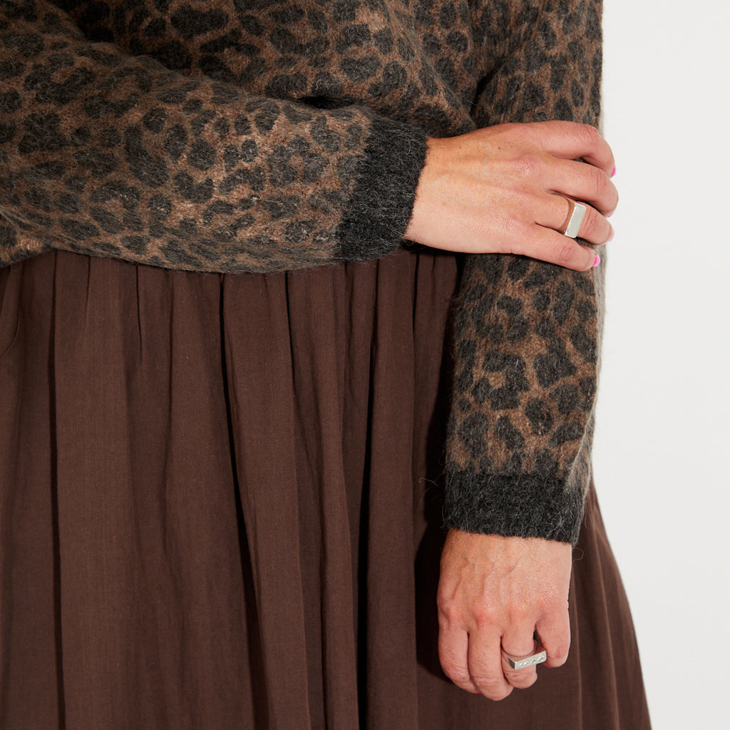 brown knitted sweater with leopard print sleeves and a chocolate brown skirt.