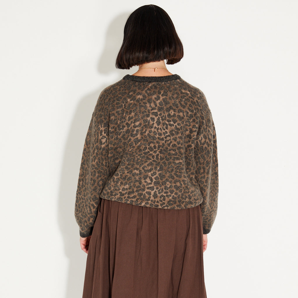 woman wearing a leopard print knitted jumper and chocolate brown a-line skirt