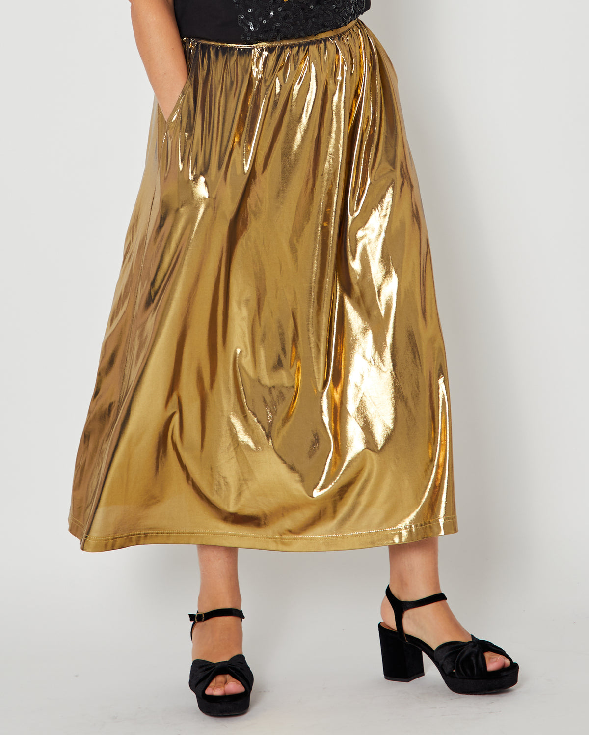 Gold metallic a line skirt close up showing pocket styled with party heels for christmas and new year