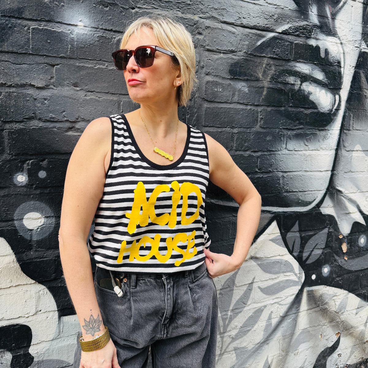Black and white striped tank top with yellow 'ACID HOUSE' text on a white background