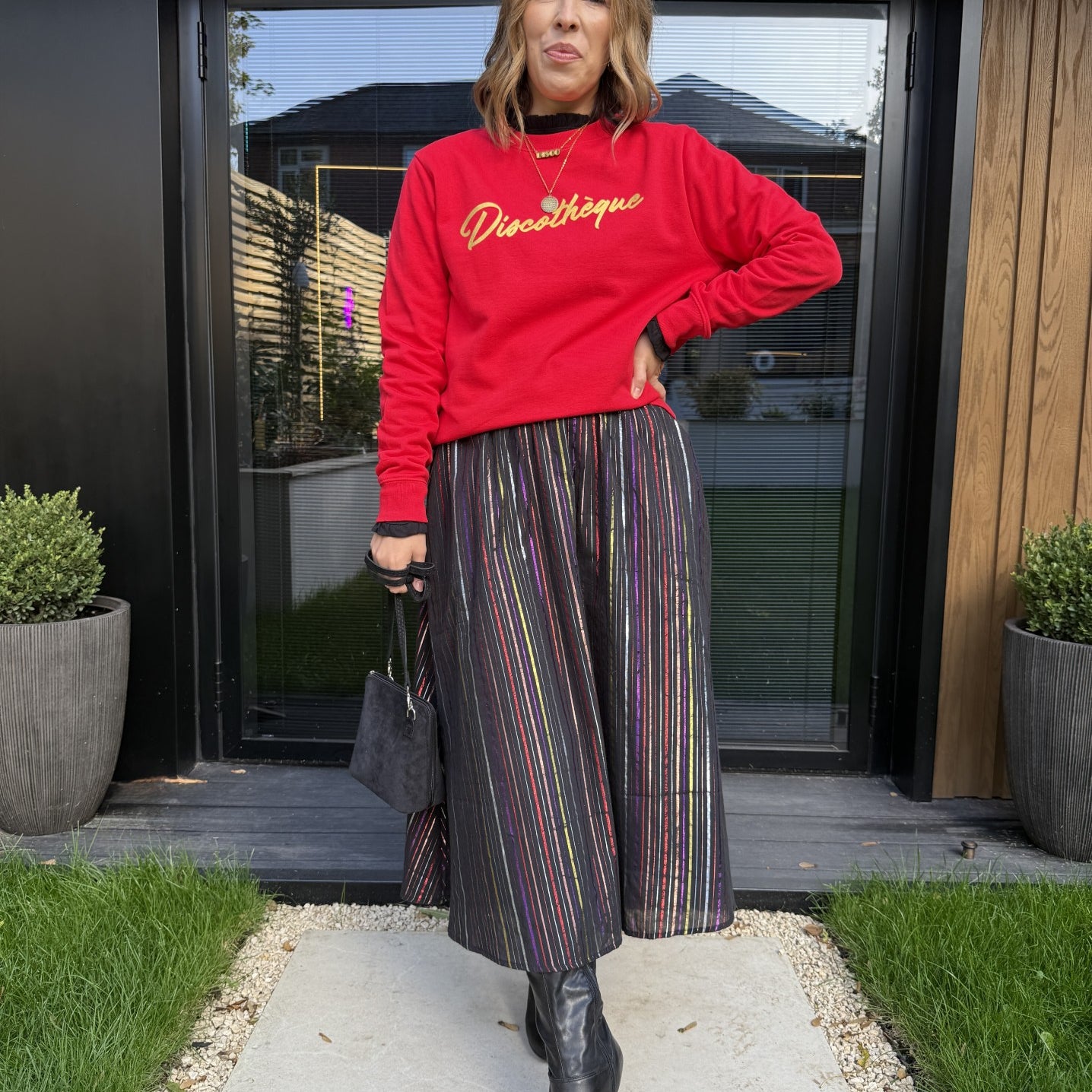 red sweatshirt with gold 'discotheque' writing and a metallic stripe rainbow skirt