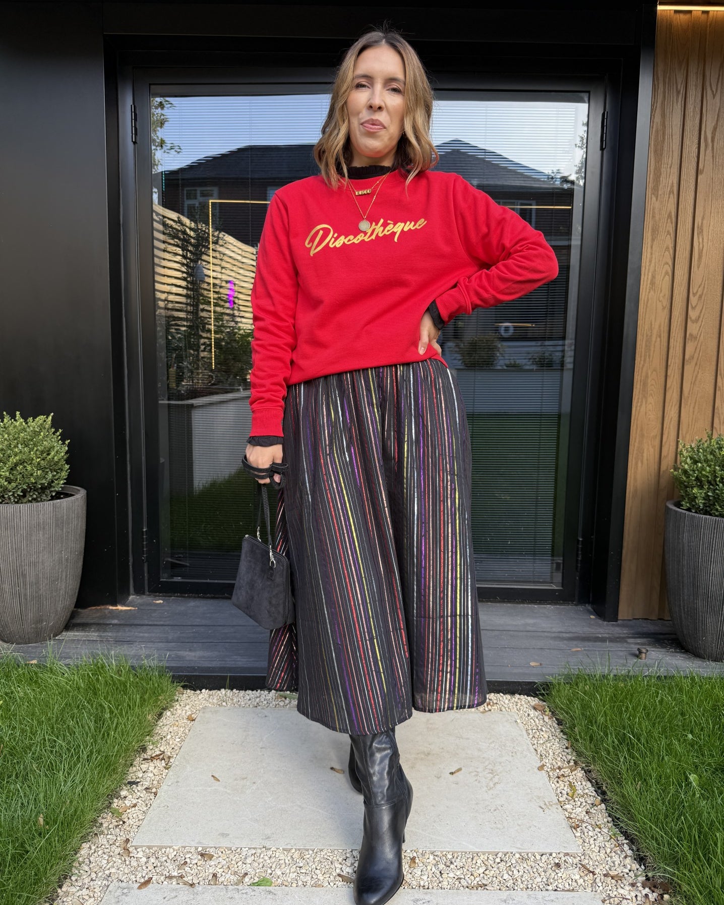 red sweatshirt with gold 'discotheque' writing and a metallic stripe rainbow skirt