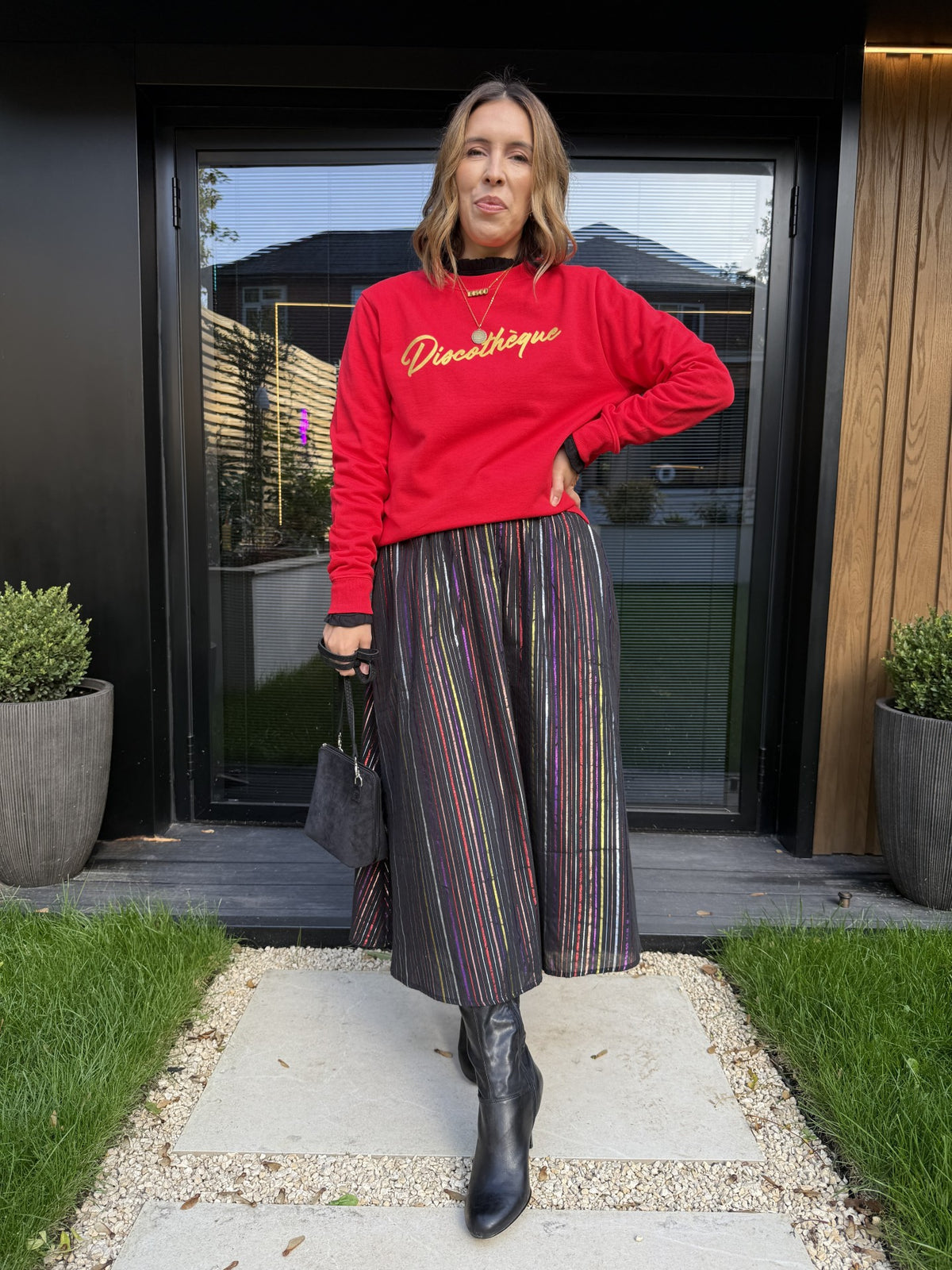 red sweatshirt with gold 'discotheque' writing and a metallic stripe rainbow skirt