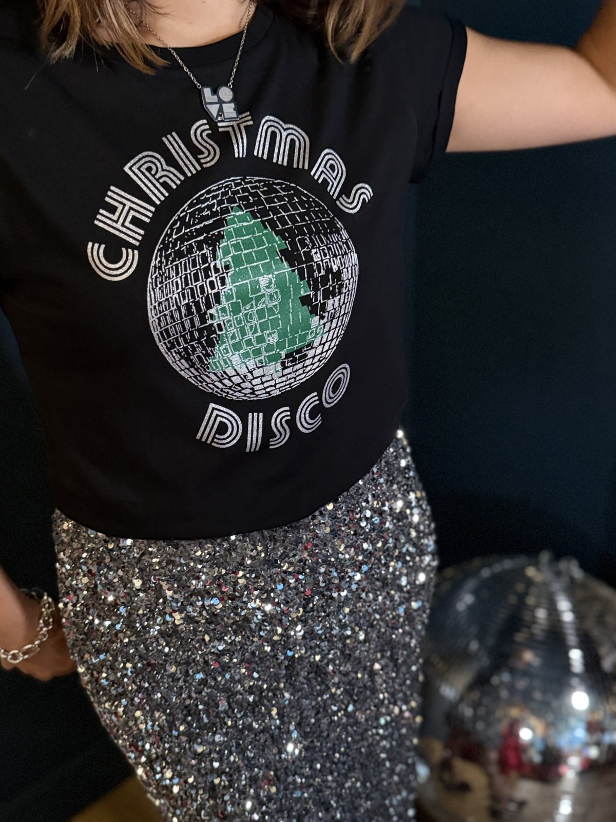 Close up of Christmas Disco tshirt with LOVE pendant necklace and silver sequin skirt