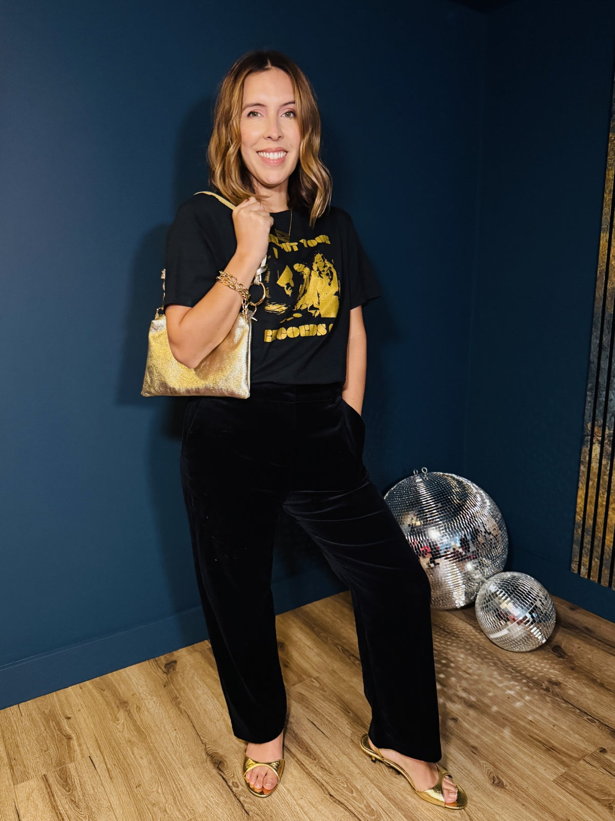 girl put your records on black tshirt with gold metallic bag