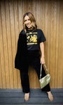 girl put your records on black tshirt with black suit and gold bag