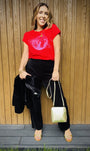 red tshirt with shattered disco ball black trousers and a gold bag for a christmas outfit