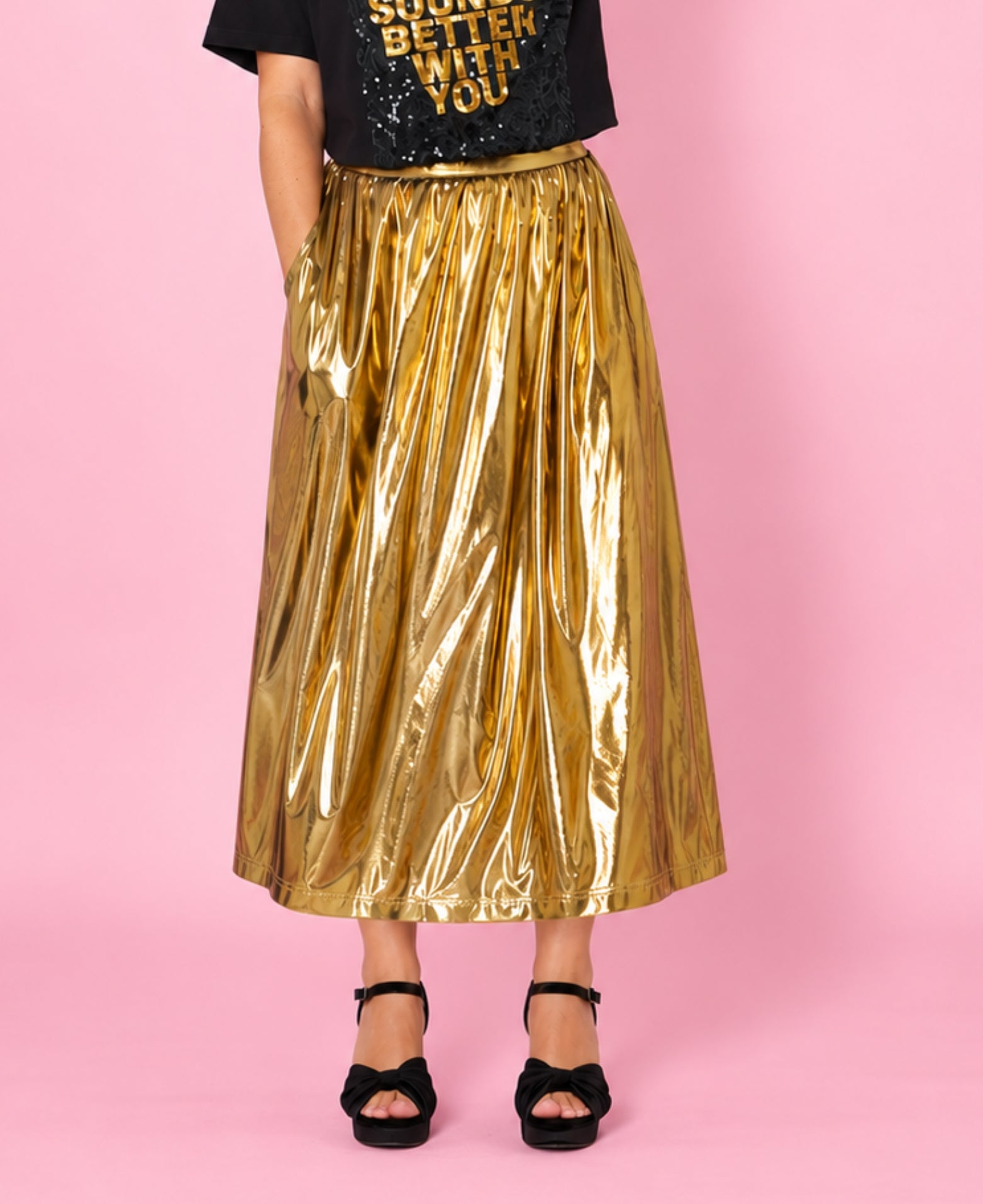 Gold metallic a line skirt close up styled with sequin Tshirt disko kids and party heels for christmas and party season showing pocket detail