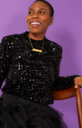 Black Sequin Long Sleeve Top styled with gold DISCO pendant with tulle skirt seated pose